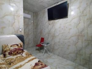 1 dormitorio con 1 cama y TV en la pared en Near Grosir Stono 2, en Pekalongan