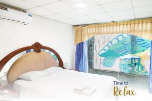 um quarto com uma cama e uma fotografia de um guarda-chuva em Hotel La Cascada - Lago Agrio em Nueva Loja