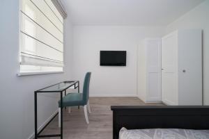 a bedroom with a bed and a desk and a chair at New apartment next to Cathedral Square in Vilnius