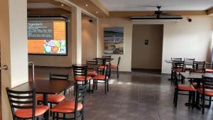 a dining room with tables and chairs and a menu at Combate Beach Resort in Cabo Rojo