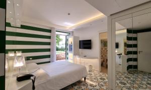 a bedroom with a green and white striped wall at Hotel Alpha in Sant'Agnello