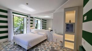 a bedroom with a bed and a tub and a television at Hotel Alpha in Sant'Agnello