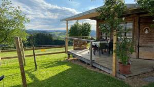 una terraza de madera con una mesa en una casa en Romantisches Gästehäuschen, 