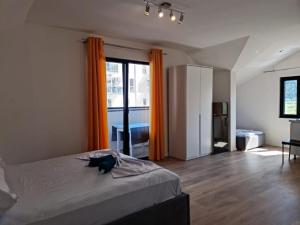 1 dormitorio con 1 cama con cortina naranja en Vila Lazri, en Skataj