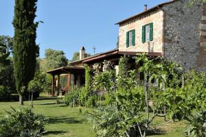 ein altes Steinhaus mit Bäumen davor in der Unterkunft Casa Maria in Magliano in Toscana