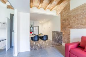 sala de estar con sofá rojo y pared de ladrillo en Aparteasy - Deluxe Family Apartments with Pool, en Barcelona