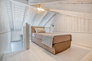 - une chambre avec un lit dans une pièce dotée de fenêtres dans l'établissement Lumiére spetses, à Spetses