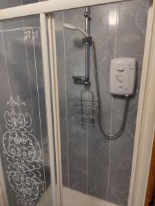 a shower in a bathroom with graffiti on the wall at 6 Connorville in Luddan