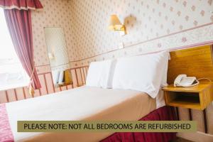 ein Hotelzimmer mit einem Bett und einem Telefon in der Unterkunft Park House Hotel in Blackpool