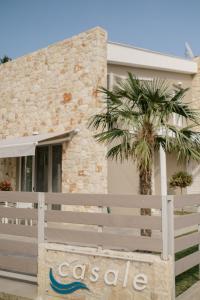 a house with a fence and a palm tree at casale in Nikiti