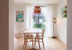 comedor con mesa, sillas y ventana en FLH Amoreiras Wood Design Flat, en Lisboa