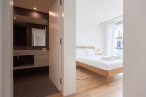 1 dormitorio con cama, lavabo y espejo en FLH Amoreiras Wood Design Flat, en Lisboa