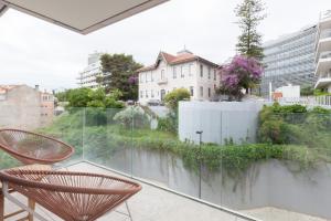 balcón con sillas y vistas a un edificio en FLH Amoreiras Wood Design Flat, en Lisboa