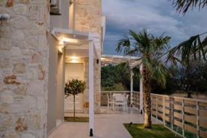 a patio of a house with a palm tree at Casale Luxury House - Luxury Garden Maisonettes in Nikiti