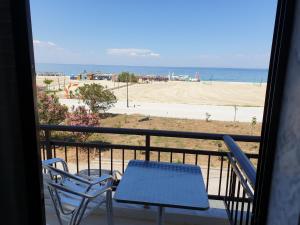 a balcony with two chairs and a table and the beach at Blue Horizon in Nei Poroi