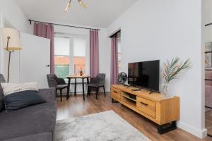 a living room with a couch and a tv and a table at Charming Old Town Gdańsk by Renters in Gdańsk