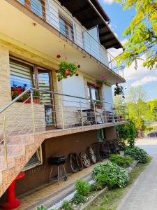 a building with a balcony and a table and chairs at APARTAMENTY W BIESZCZADACH in Berezka
