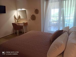 a bedroom with a bed and a desk and a window at Rousis Studios in Parga