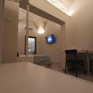 - un salon avec une table et une télévision murale dans l'établissement 18 MQ, à Pulsano