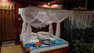 ein Himmelbett mit einer Person, die darauf liegt in der Unterkunft Bukit Lawang Hill Resort in Bukit Lawang