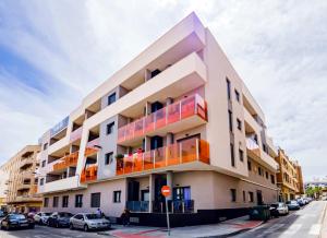 un immeuble avec des balcons colorés dans une rue dans l'établissement Alegria ID 11, à Torrevieja