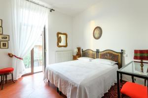 Dormitorio blanco con cama y mesa de cristal en Residenza di Prestigio In Riva al Lago Marone Primo Piano, en Marone