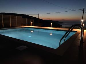 a swimming pool at night with a view of the ocean at Villa Athina in Angón