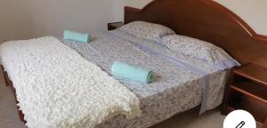 a bed with two blue pillows on it at Beach house Cala Morlanda in S'Illot