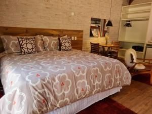 a bedroom with a bed and a table and chairs at Pousada Toca Da Coruja in Monte Verde