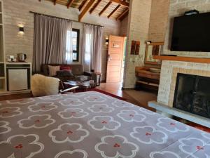 a living room with a bed and a fireplace at Pousada Toca Da Coruja in Monte Verde