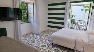 a room with two beds and a flat screen tv at Hotel Alpha in Sant'Agnello