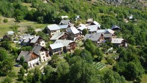 um grupo de casas numa colina com árvores em maison immersion hautes alpes em Freissinieres
