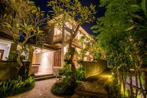 una casa con jardín por la noche en Lili Cottage Ubud en Ubud