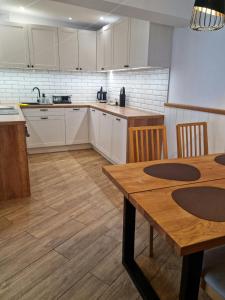 a kitchen with white cabinets and a table and chairs at TU i TERAZ apartament in Ustka