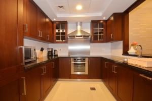 a kitchen with wooden cabinets and a stove top oven at Vacation Bay - 29 Boulevard Downtown in Dubai