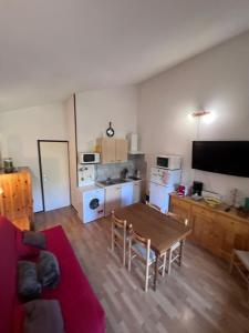 a living room with a red couch and a table at Résidence les Cristallines in Le Lioran