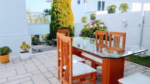 a glass table and chairs on a patio at GB Rooms in Ksamil