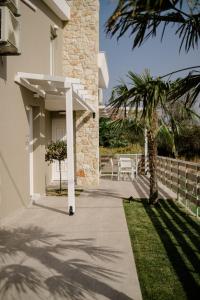 a walkway leading to a house with a palm tree at casale in Nikiti