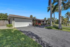 a house with a garage and palm trees at Alfresco Beach Getaway in Pompano Beach