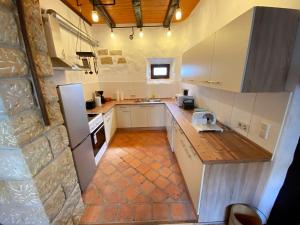 a kitchen with white appliances and a stone wall at Ferienhaus NAMIBIA-LODGE im Rittergut Leppersdorf bei Dresden in Wachau