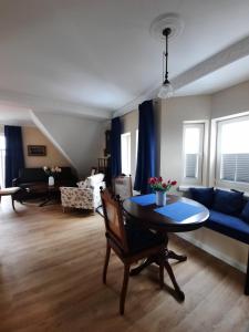 a living room with a table and a blue couch at Logierhaus am Meer in Wangerooge