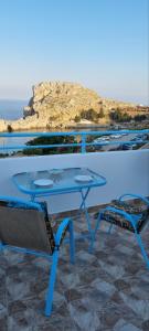 a blue table and two chairs sitting on a balcony at St Paul's Studios Chrysanthi in Lindos