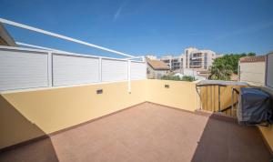 a balcony of a house with a yellow wall at R129 Apartamento con terraza y piscina comunitaria cerca de la playa in Calafell