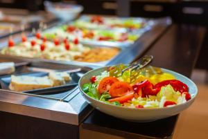 a salad in a bowl on a counter with other foods at Hotel Bor in Krk