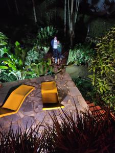 dos personas caminando por un jardín por la noche en La Finestra Spa Hotel Boutique en La Vega