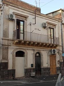 een oud gebouw met een balkon erboven bij 3D House Catania centro in Catania