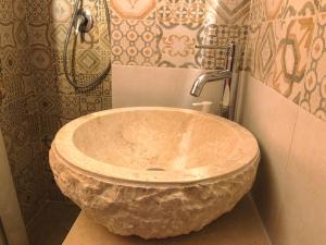 ein Badezimmer mit einem großen Steinwaschbecken in der Dusche in der Unterkunft Tao Stones - Alloggio in pietra in Conversano