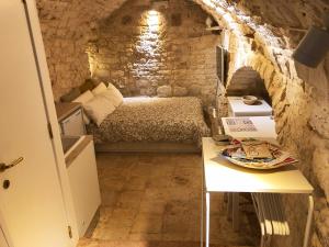 Kleines Zimmer mit einem Bett und einem Tisch in der Unterkunft Tao Stones - Alloggio in pietra in Conversano