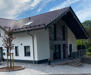 una casa bianca con il tetto marrone di MorgenSonne a Simmerath