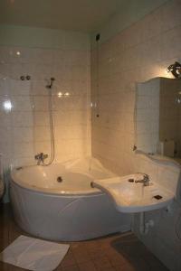 La salle de bains est pourvue d'une baignoire blanche et d'un lavabo. dans l'établissement Airone Hotel, à Reggio d'Émilie